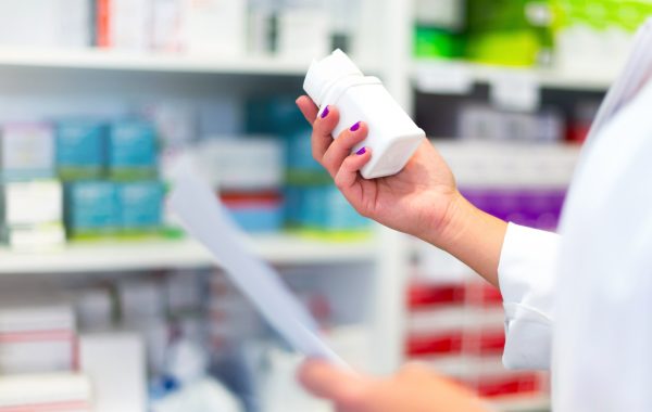 Woman customer in the pharmacy taking a medicine box