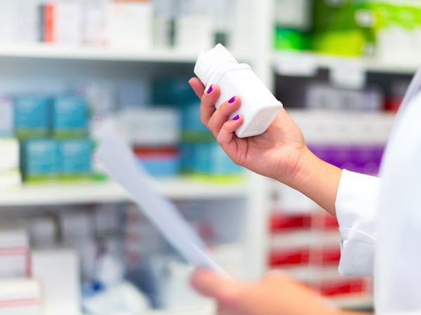 Woman customer in the pharmacy taking a medicine box